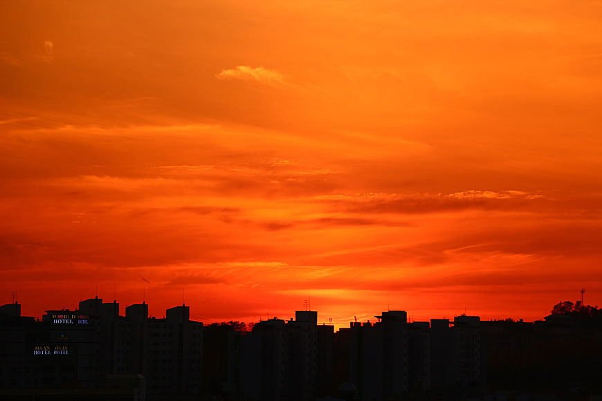 Vibrant orange sunset sky over city skyline silhouette
