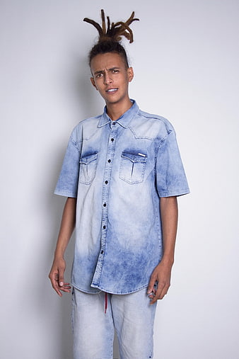 Young man with dreadlocks wearing oversized denim shirt