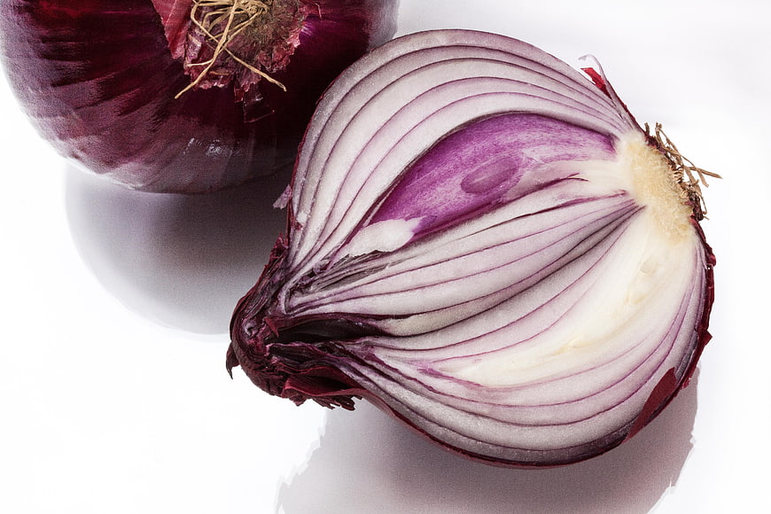 Red Onion Cut in Half Showing Layers on White Background