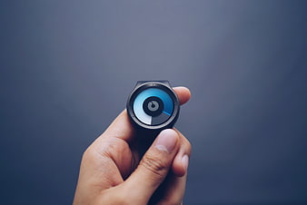 Hand holding a modern smartwatch with a blue digital display