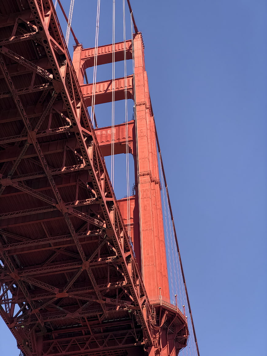 Low angle view of Golden Gate Bridge steel structure against blue sky