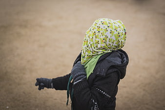 Child in winter clothes with green patterned headscarf