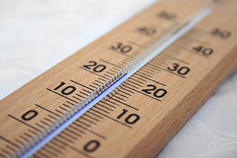 Close-up of wooden thermometer showing temperature measurement