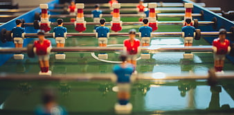 Close-up of foosball table players in red and blue uniforms