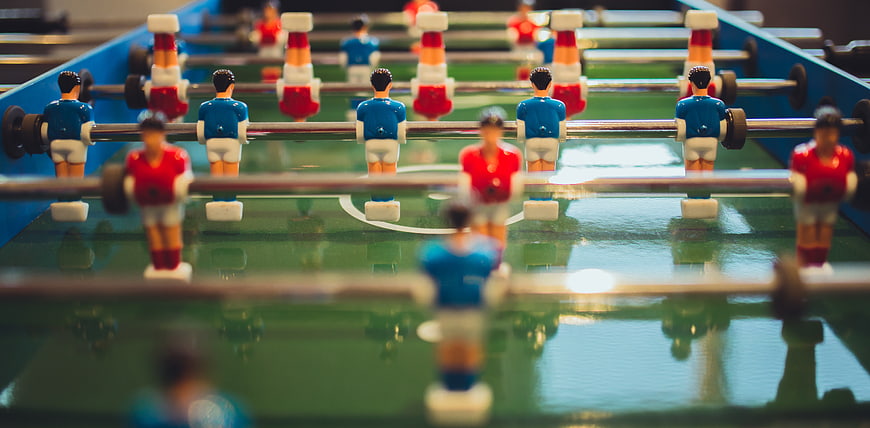 Close-up of foosball table players in red and blue uniforms