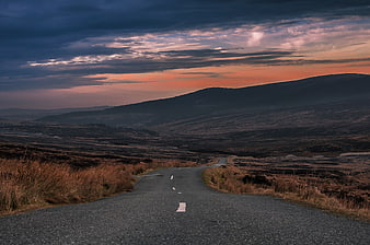Winding Country Road Through Moorland at Sunset