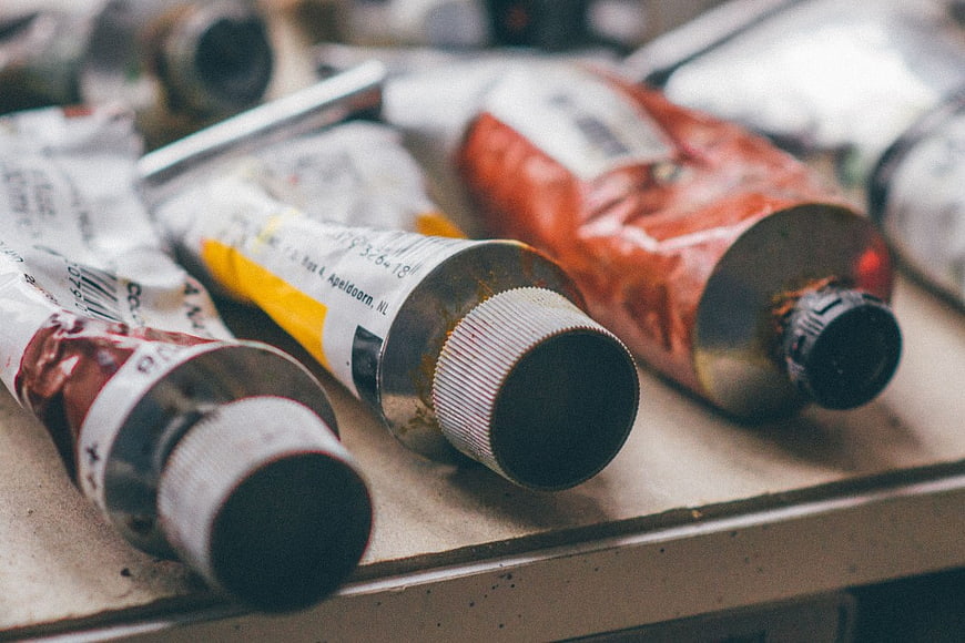 Close-up of used oil paint tubes on artist palette