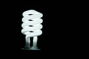 Illuminated CFL Light Bulb on Black Background