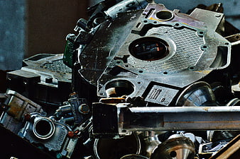 Close-up of scrap metal engine parts and pistons in junkyard