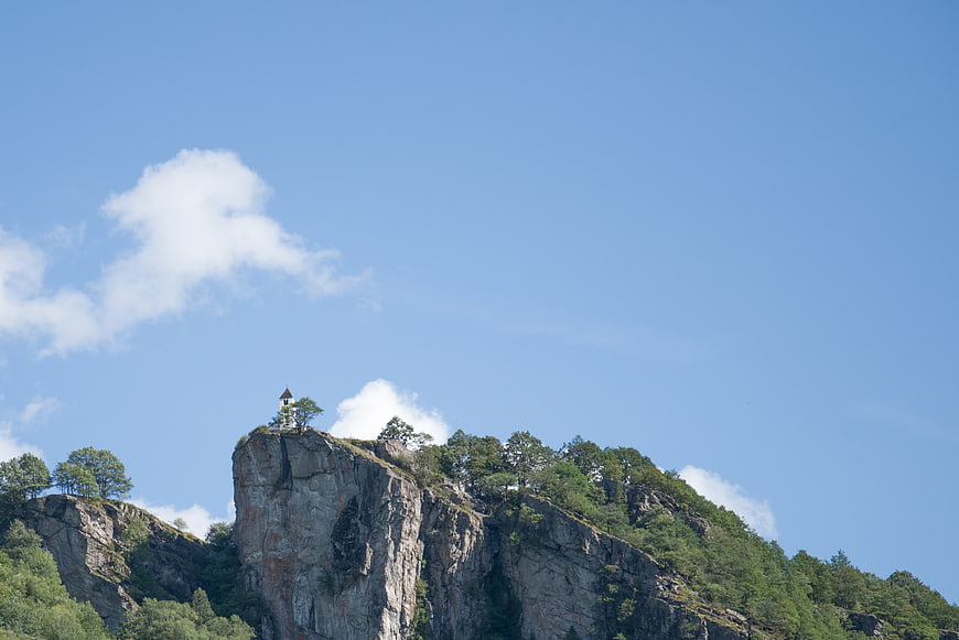Small Chapel on Rocky Mountain Peak Under Blue Sky
