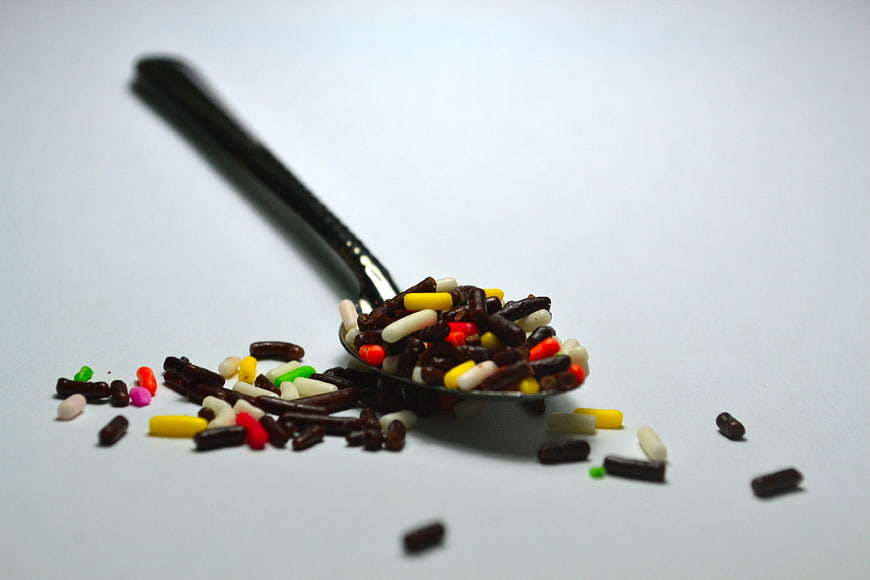 Colorful Sprinkles On A Spoon Against A White Background