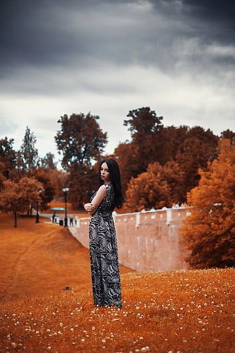 Woman in Black and White Dress Standing in Autumn Park