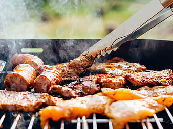 Close-up of Sizzling Sausages and Steak on Outdoor Grill