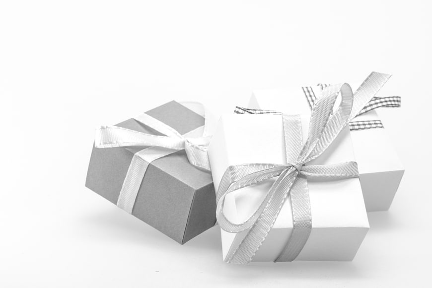 Three wrapped gift boxes with ribbons on white background