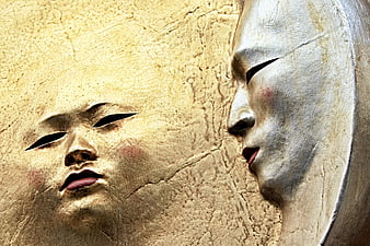 Close-up of textured gold and silver sun and moon masks