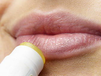 Close-up of applying lip balm to dry lips