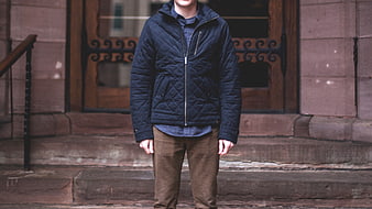 Man Wearing Navy Quilted Jacket on Stone Steps