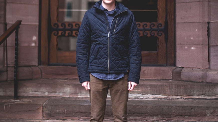 Man Wearing Navy Quilted Jacket on Stone Steps
