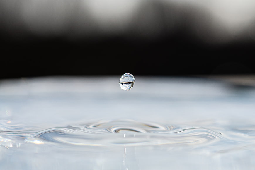 Macro photography of a water droplet splashing into a pool