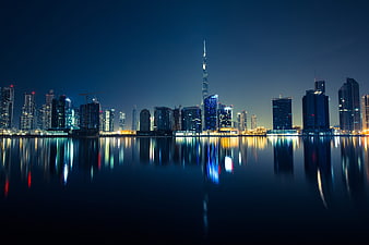 Dubai skyline at night with Burj Khalifa and water reflections