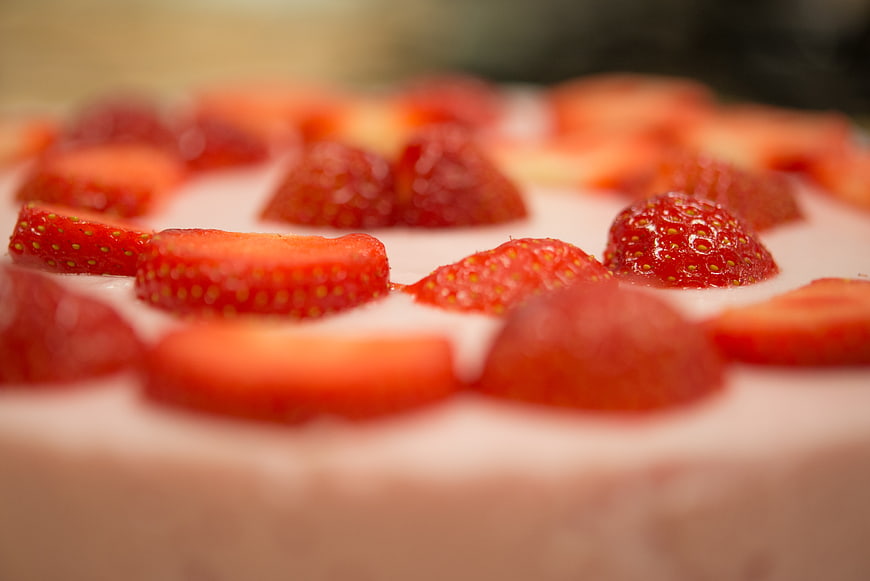 Close-up of fresh strawberry slices on creamy cake