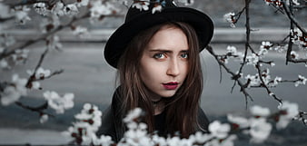 Woman in Black Hat with Red Lips Among White Blossoms
