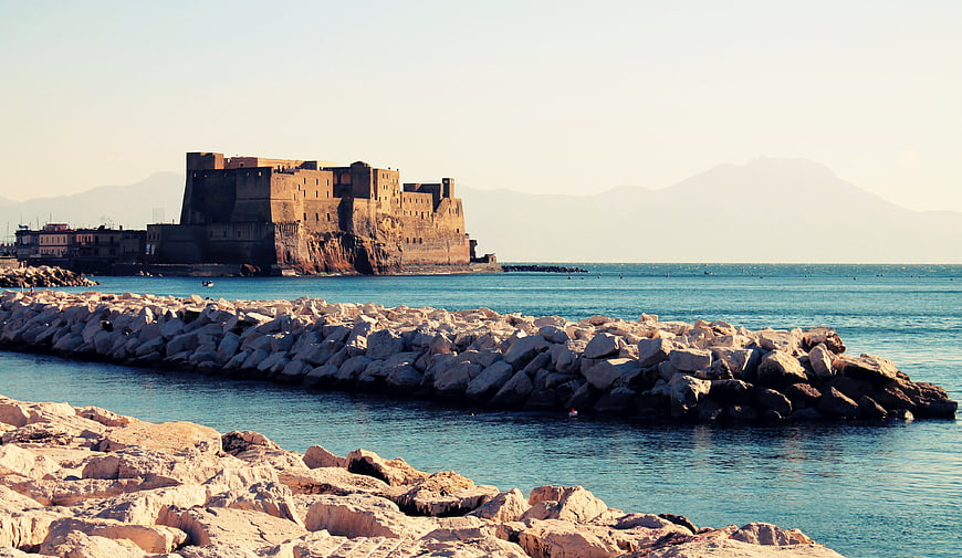 Castel dell'Ovo in Naples with rocky breakwater and calm sea