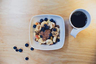 Overhead view of healthy breakfast bowl with fruit and coffee