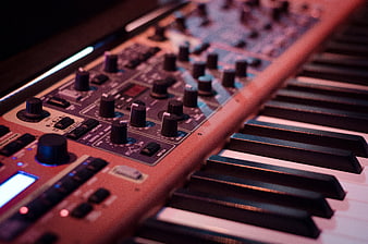 Close-up of vintage synthesizer keyboard with knobs and controls