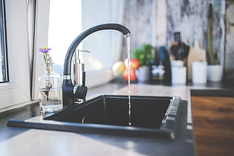 Modern black kitchen faucet with running water and flower