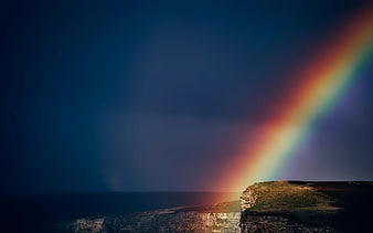 Vibrant Rainbow Over Coastal Cliffs at Sunset