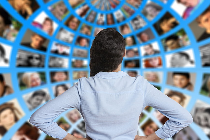 Woman facing digital network of diverse faces