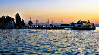 Sunset View of Harbor with Sailboats and Ferry on Lake