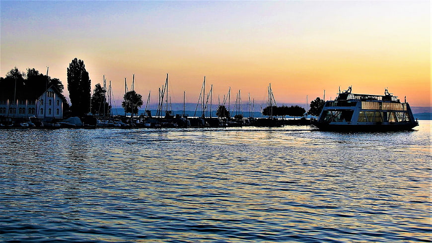Sunset View of Harbor with Sailboats and Ferry on Lake