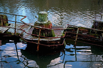 Rusty Dock Bollard with Reflection in Calm Water