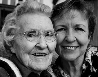 Black and white portrait of elderly mother and daughter smiling