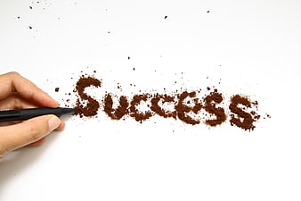 Hand writing success with coffee powder on white background
