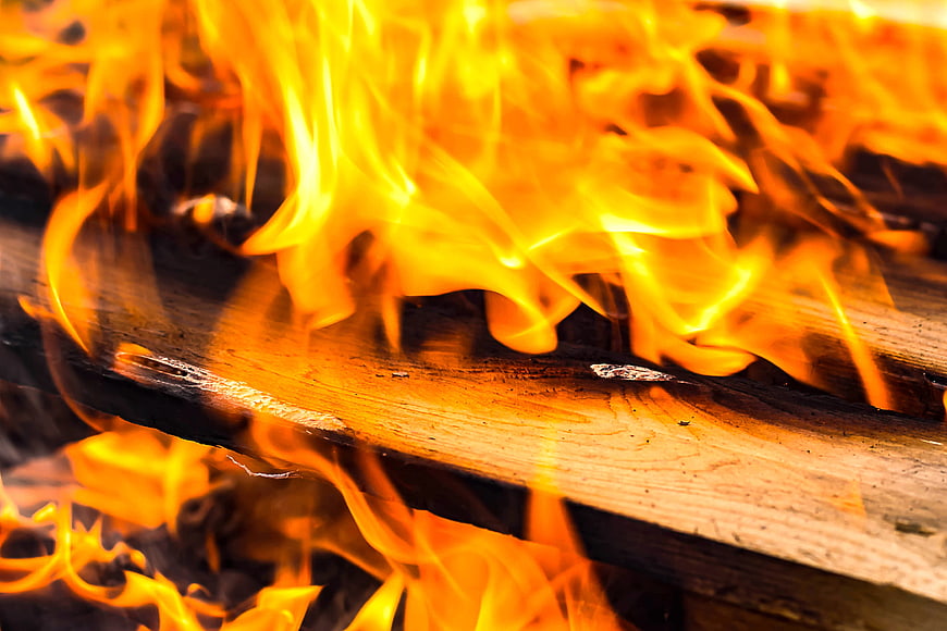 Close-up of burning wood logs with bright orange flames