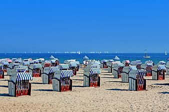 Traditional striped beach chairs on sandy Baltic Sea coast