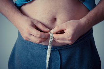 Man Measuring Belly Fat with Tape Measure