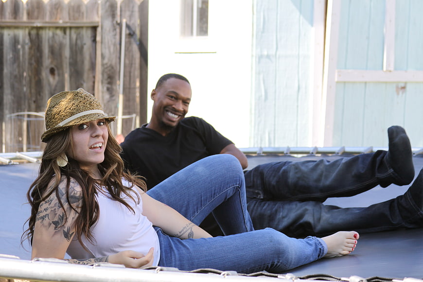 Happy young couple relaxing on a trampoline outdoors
