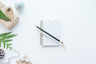 Christmas flat lay with notebook, pencils, and holiday gifts