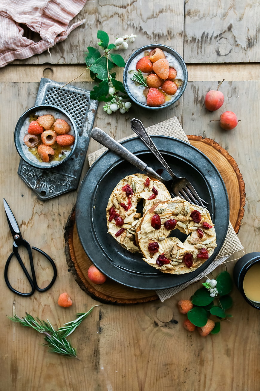 Rustic breakfast bagels with yogurt and berries on wooden table