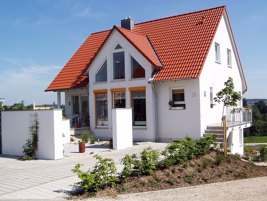 Modern white house with red tiled roof and garden