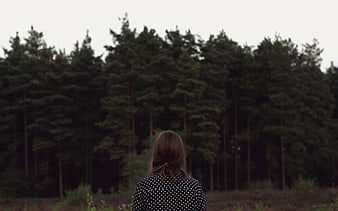 Woman Looking at Dark Pine Forest from Behind