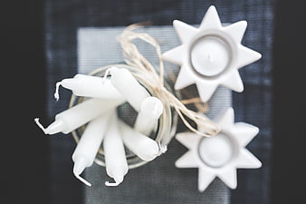 Top view of white taper candles and star-shaped holders