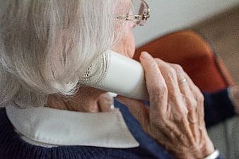 Senior Woman Talking On White Telephone Receiver
