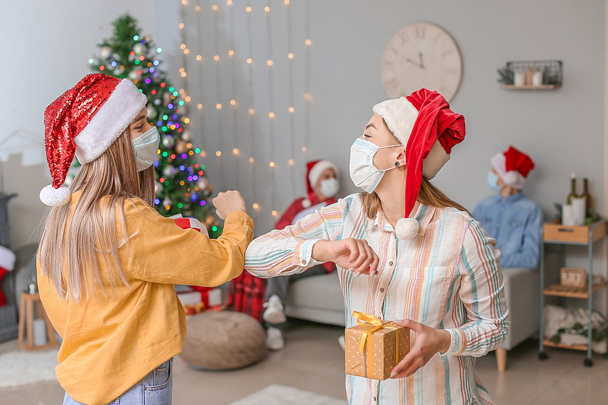Family celebrating Christmas with face masks and elbow bump