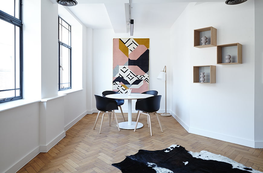 Modern dining room with herringbone floor and abstract art