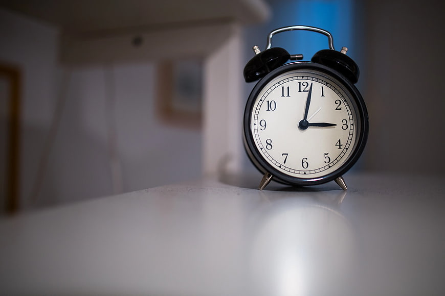 Black Alarm Clock on White Surface with Copyspace